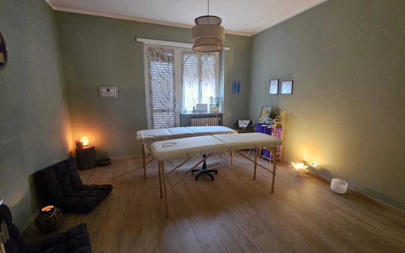 Studio naturopata a Moncalieri con lettino per trattamenti olistici, ambiente accogliente e illuminazione calda.